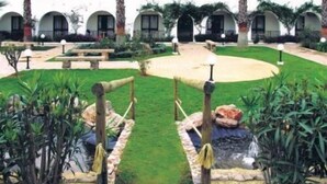 A hotel with a courtyard featuring a small pond, palm trees, and a central seating area. - Alte Hotel (Loulé)