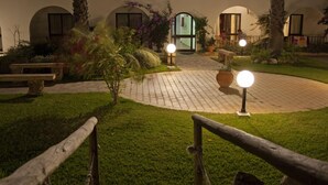 A courtyard with a paved walkway, benches, and potted plants. - Alte Hotel (Loulé)