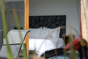 A bedroom with a bed, a chair, and a nightstand. - U Boutique Hotel, SureStay Collection by BW (Wellington)