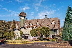 A building with a tower, multiple windows, and a green exterior. - Hotel Laghetto Premio (Gramado)