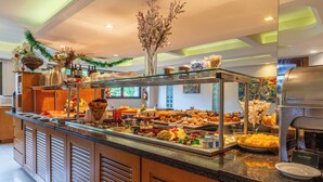A buffet with various food items and a decorative centerpiece. - Hotel Laghetto Premio (Gramado)