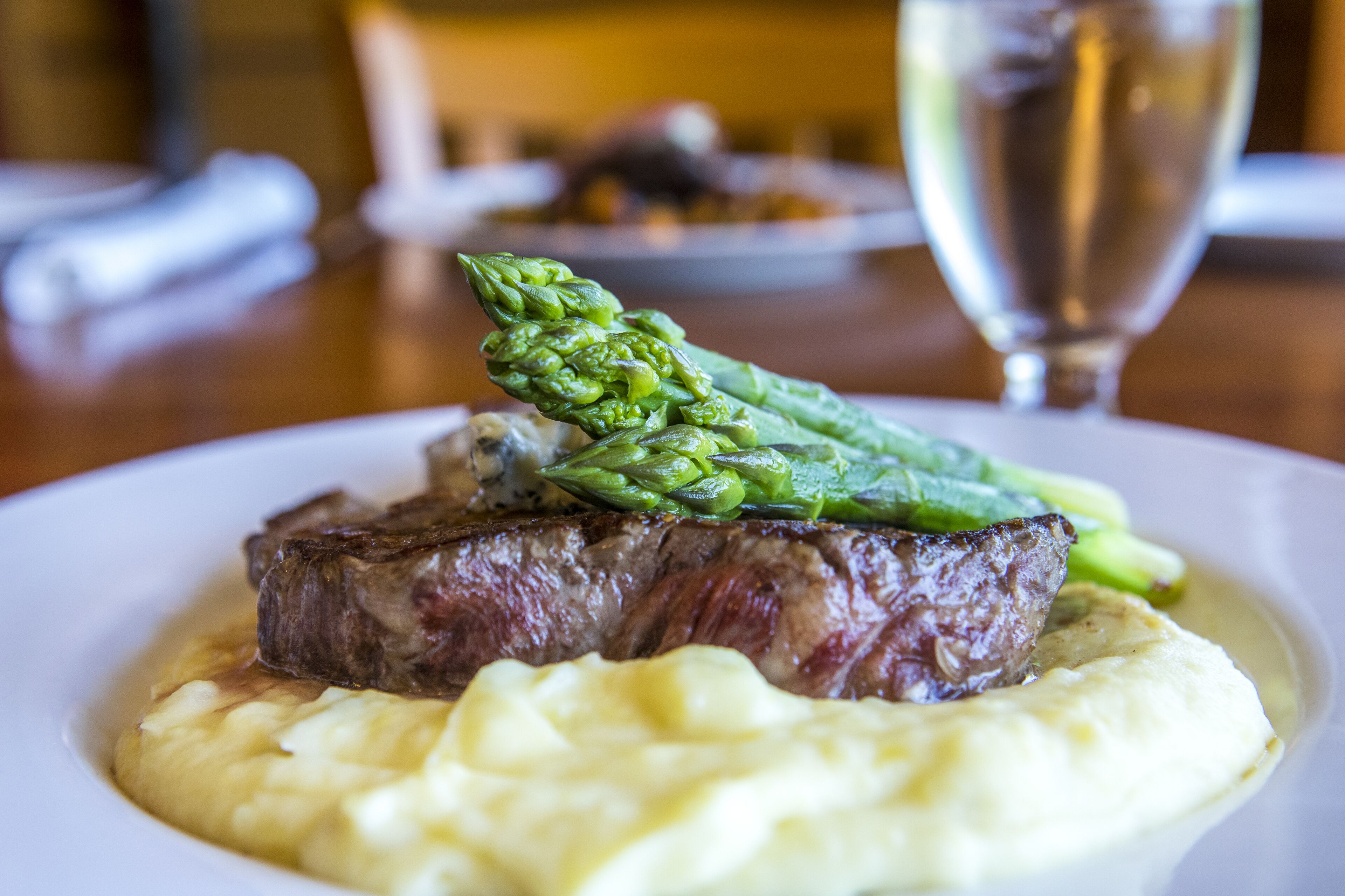 A plate of steak with asparagus and mashed potatoes.