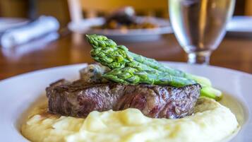 A plate of steak with asparagus and mashed potatoes.