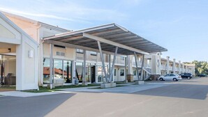 A modern hotel with a covered outdoor area, multiple balconies, and a parking lot. - Quality Inn & Suites Jasper - Kimball (Jasper)