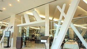 A modern interior with a glass storefront and a central white structure. - High1 Grand Hotel Convention Tower (Jeongseon)