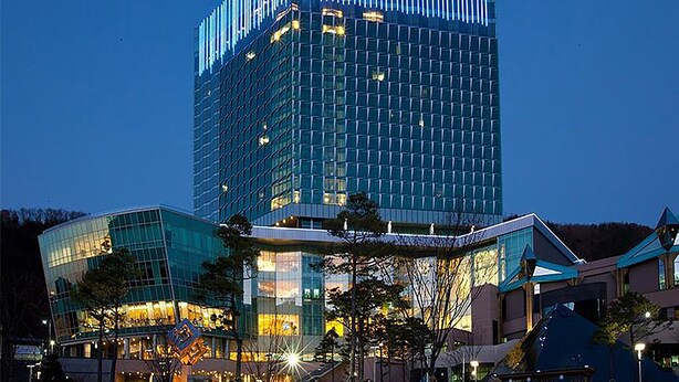 A modern high-rise building with a glass facade and a distinctive striped pattern at the top. - High1 Grand Hotel Convention Tower (Jeongseon)