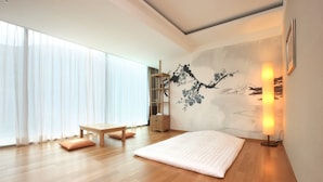 A modern room with a wooden floor, a bed, a desk, a chair, and a large window with sheer curtains. - High1 Grand Hotel Convention Tower (Jeongseon)