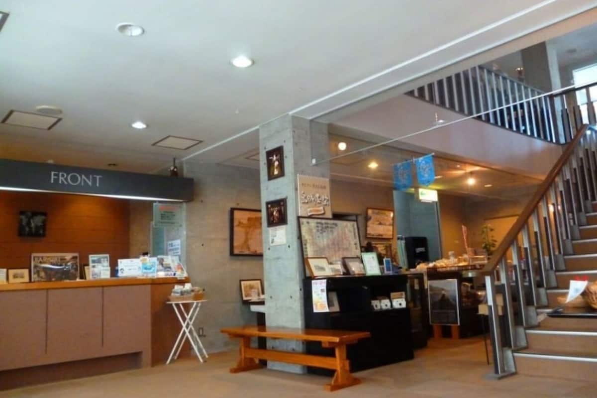 A reception area with a counter, a staircase, and a wall with framed pictures.