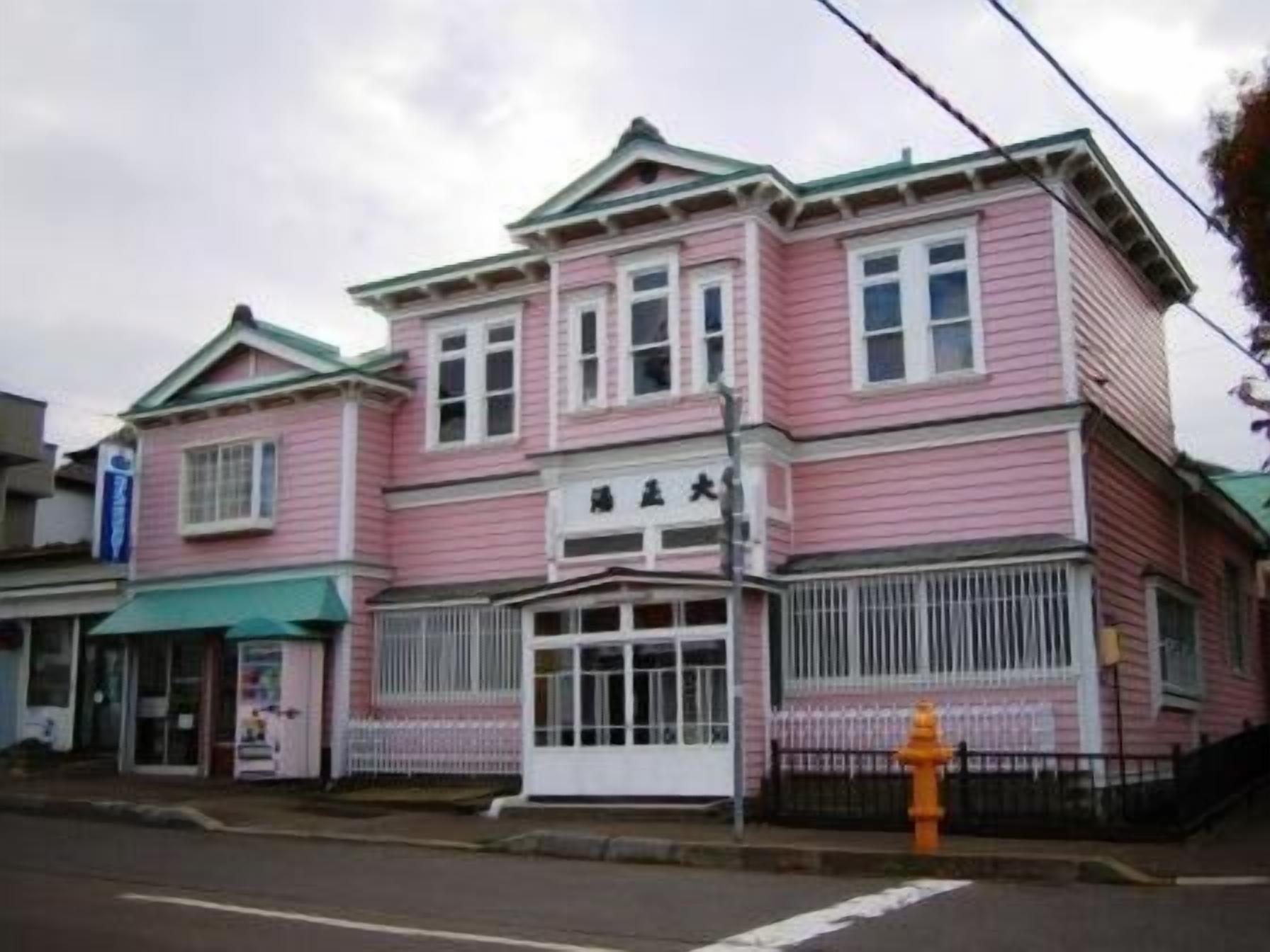 A pink building with a sign that reads "Hotel Big".
