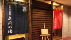 A room with a wooden floor, a small table with a painting, and a red curtain. - Hakodate Motomachi Hotel (Hakodate)