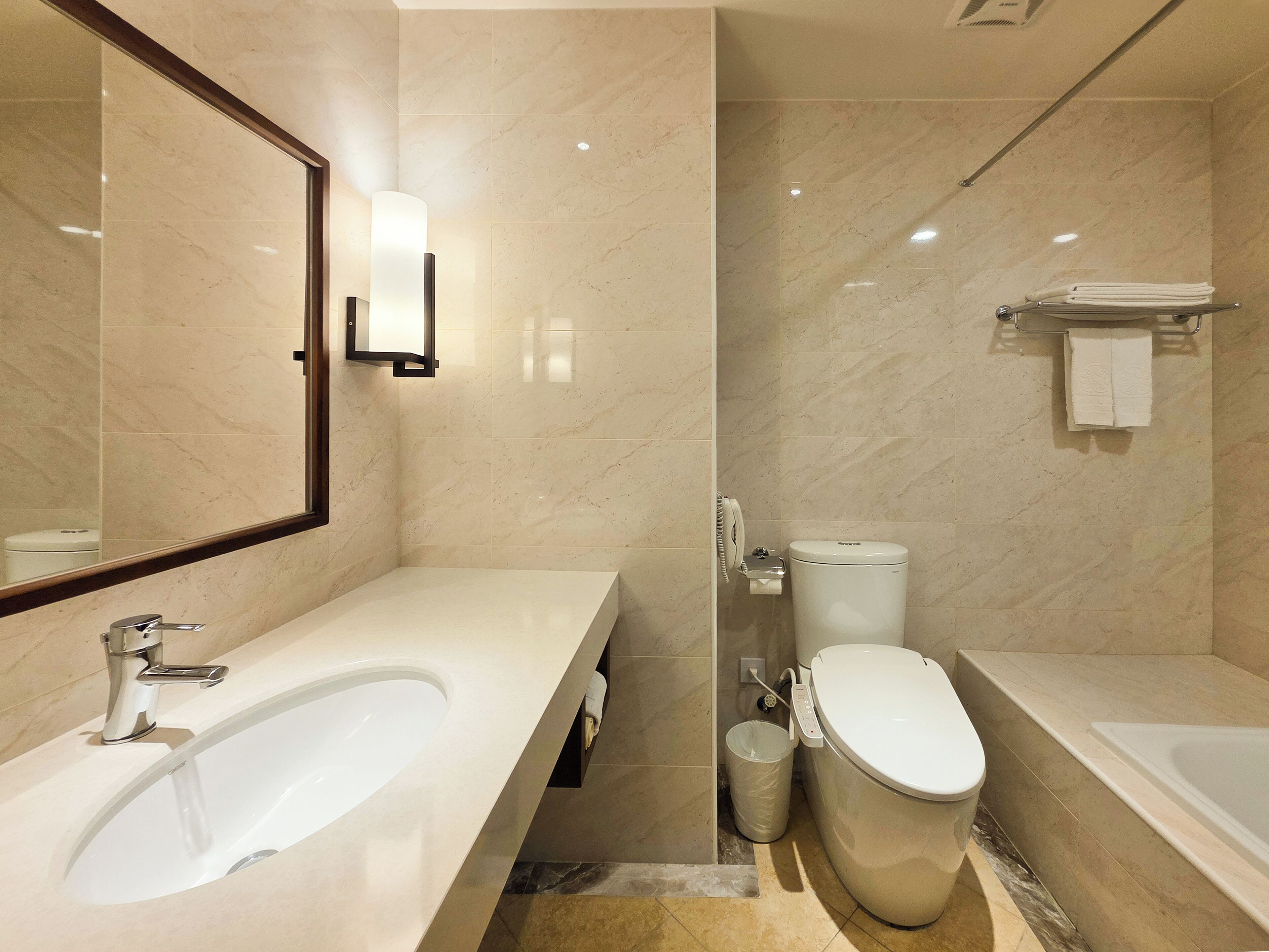 A modern bathroom with a large bathtub, a separate toilet, and a sink.