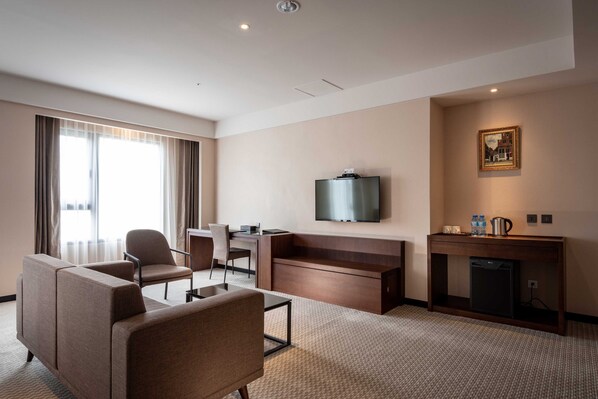 A hotel room with a sofa, chairs, a TV, a small table, a coffee maker, and a mini-fridge. - CHECK Inn Taichung LaiLai (Taichung)
