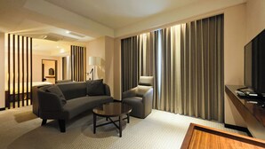 A modern hotel room with a sofa, armchair, and a small coffee table. - CHECK Inn Taichung LaiLai (Taichung)