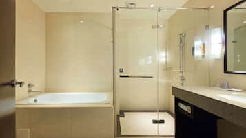 A modern bathroom with a glass-enclosed shower, a standalone bathtub, and a vanity with a mirror.