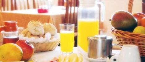 Een ontbijttafel met fruit, sap en toevoegingen.