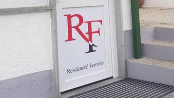 A residential property entrance with a sign indicating 'RF' and 'Residencial Ferrinho'.