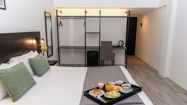 A hotel room with a bed, a desk, and a tray of breakfast items. -  Duomi Hotel Buenos Aires (Buenos Aires)