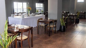 A dining area with tables set for service, chairs, and potted plants. -  Duomi Hotel Buenos Aires (Buenos Aires)