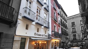 A building with multiple balconies and a ground-floor restaurant named "En busca del Tiempo". - Apartamentos El Tiempo (Madrid)