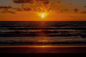 Una puesta de sol sobre el océano con olas.