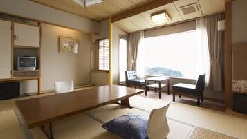 Una habitación japonesa tradicional con suelo de tatami, una mesa de madera baja y disposición de asientos.