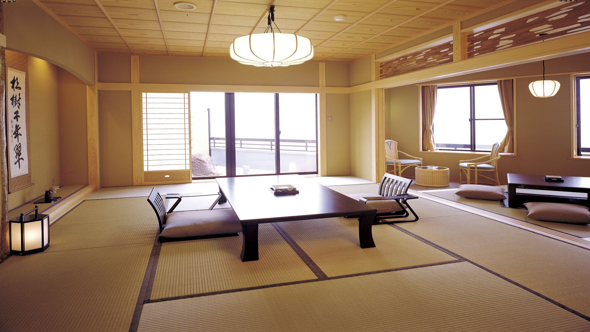 Een traditionele Japanse kamer met tatami vloerbedekking, een lage tafel en schuifdeuren.