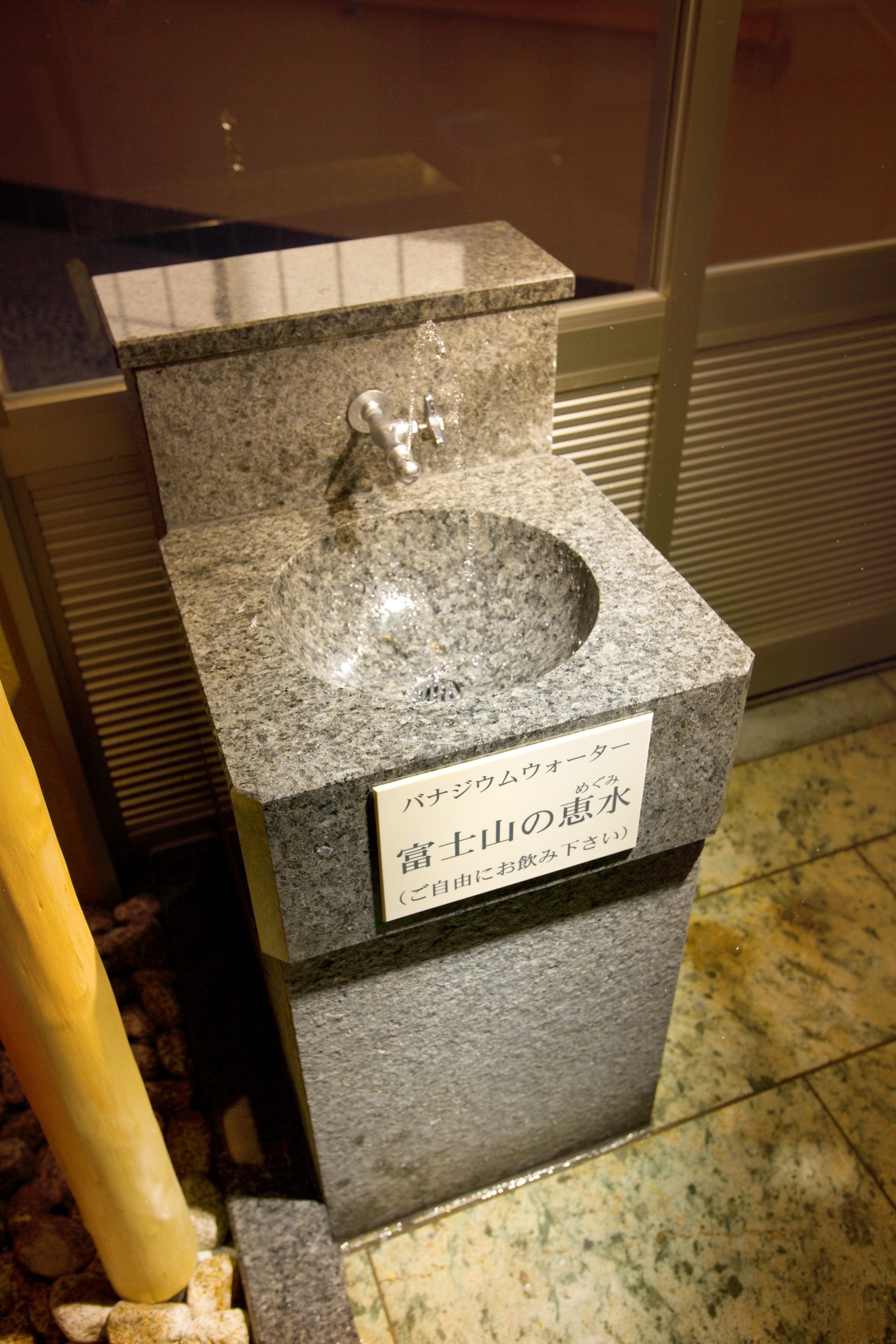 A granite sink with a faucet and a sign in Japanese.