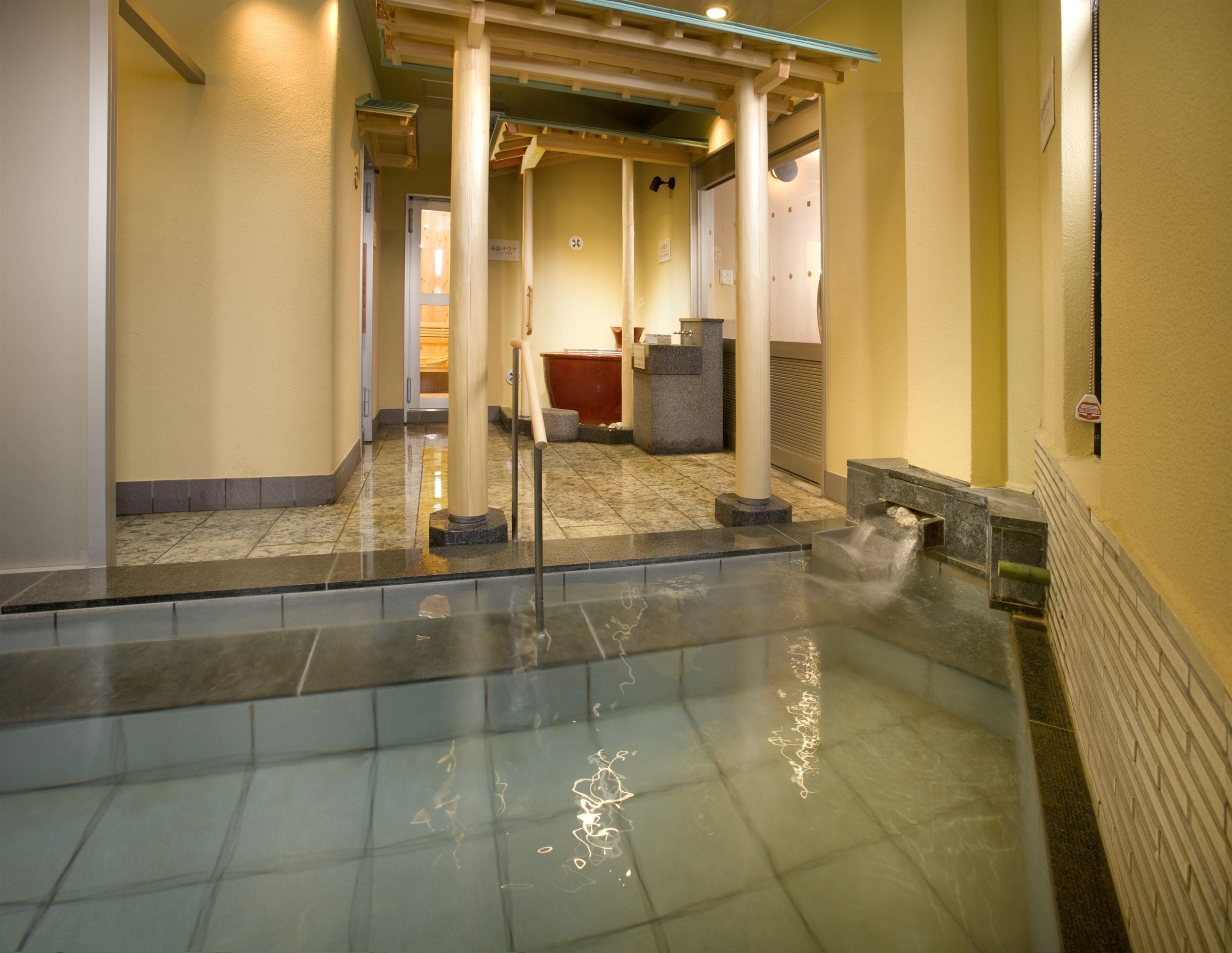 A hotel lobby with a glass-enclosed pool, a reception desk, and a waiting area.