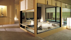 A room with a traditional Japanese-style sliding door, a small indoor garden with rocks and a water feature, and a framed picture on the wall. - Wakakusa no Yado Maruei Ryokan (Fujikawaguchiko)