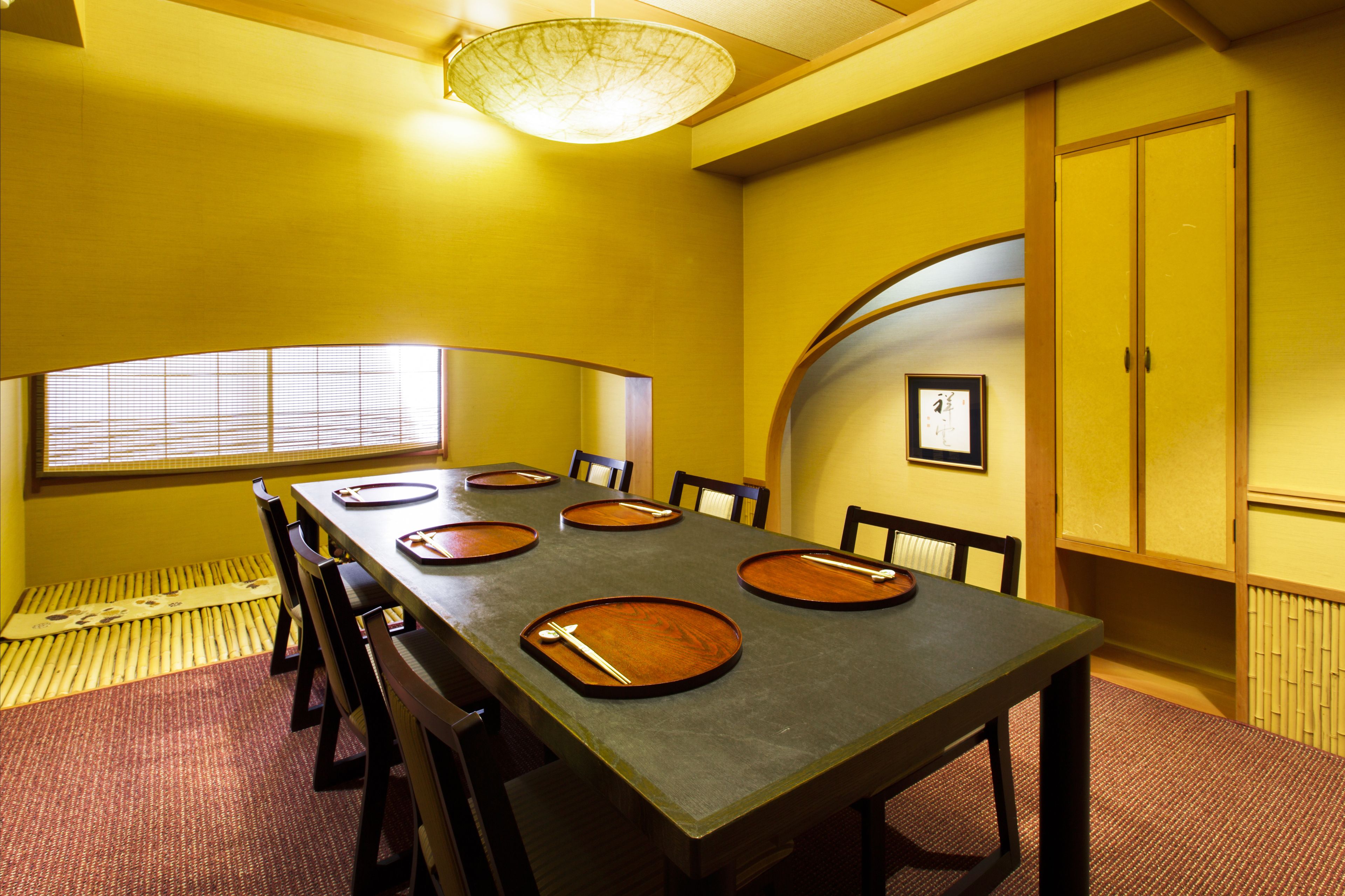 A conference room with a long table, chairs, and a large window.