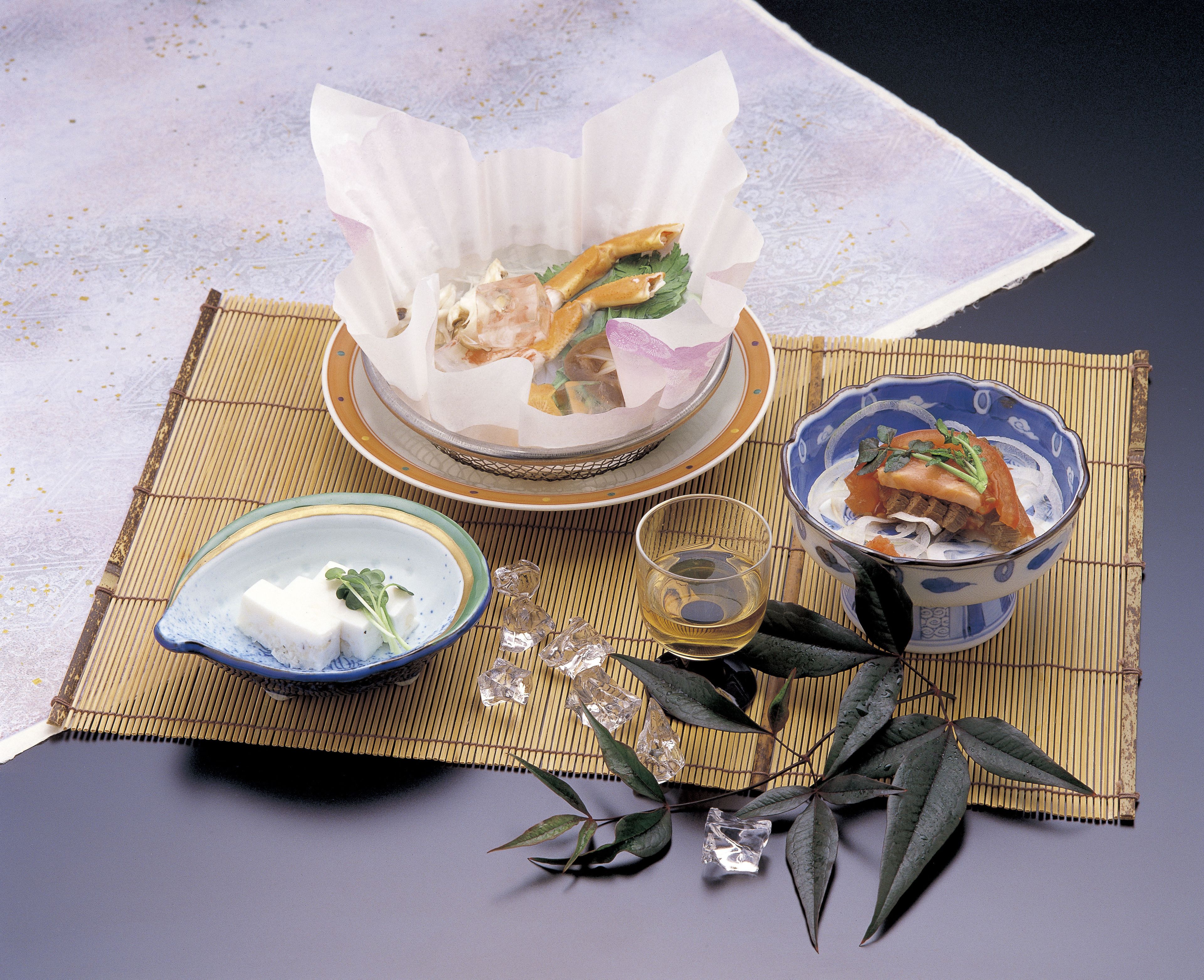 A traditional Japanese meal setup with a bowl of soup, a plate of sashimi, and a small dish of wasabi.