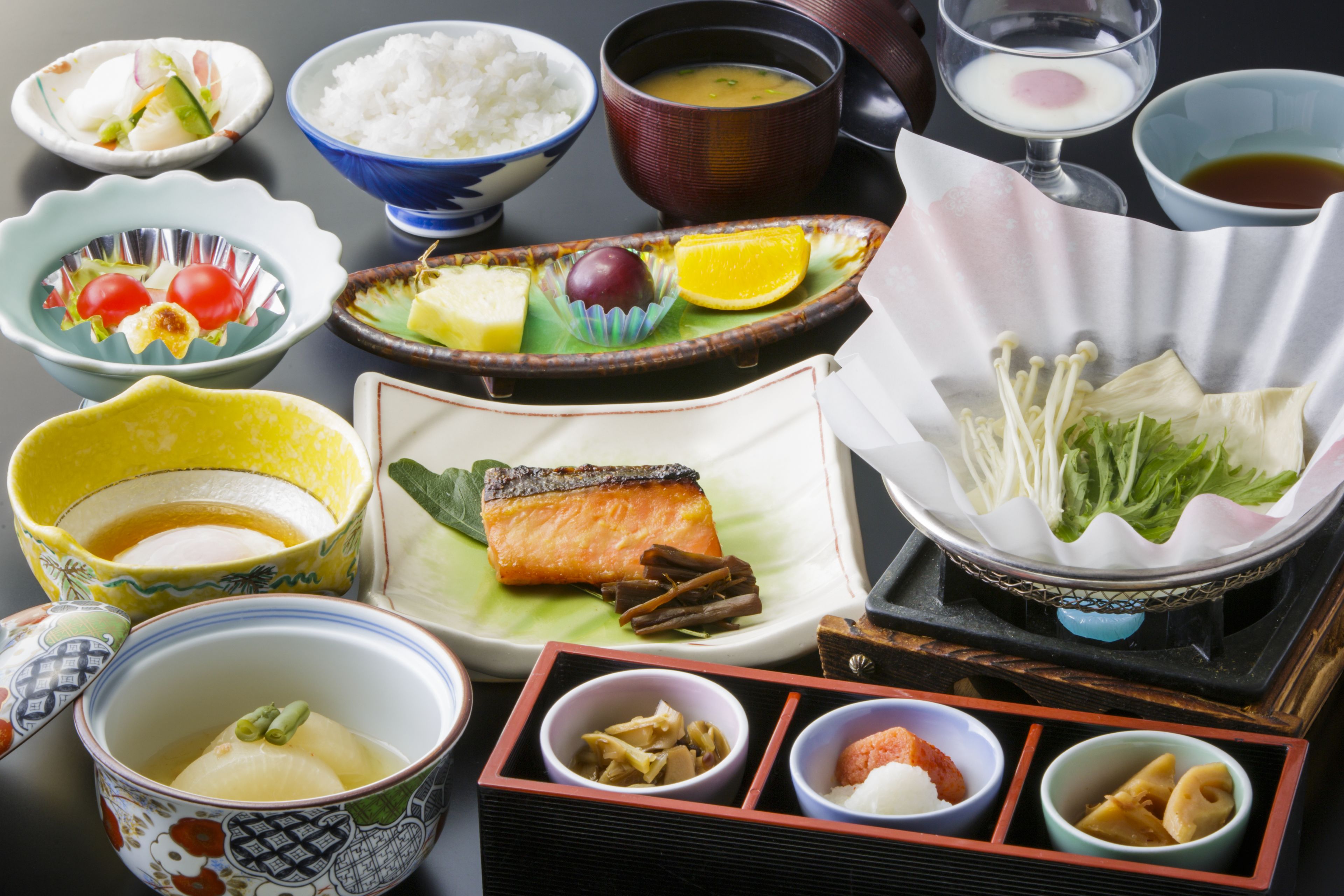 A variety of Japanese dishes including sushi, rice, and soup, arranged on a table.