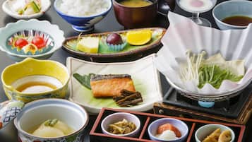 A variety of Japanese dishes including sushi, rice, and soup, arranged on a table.