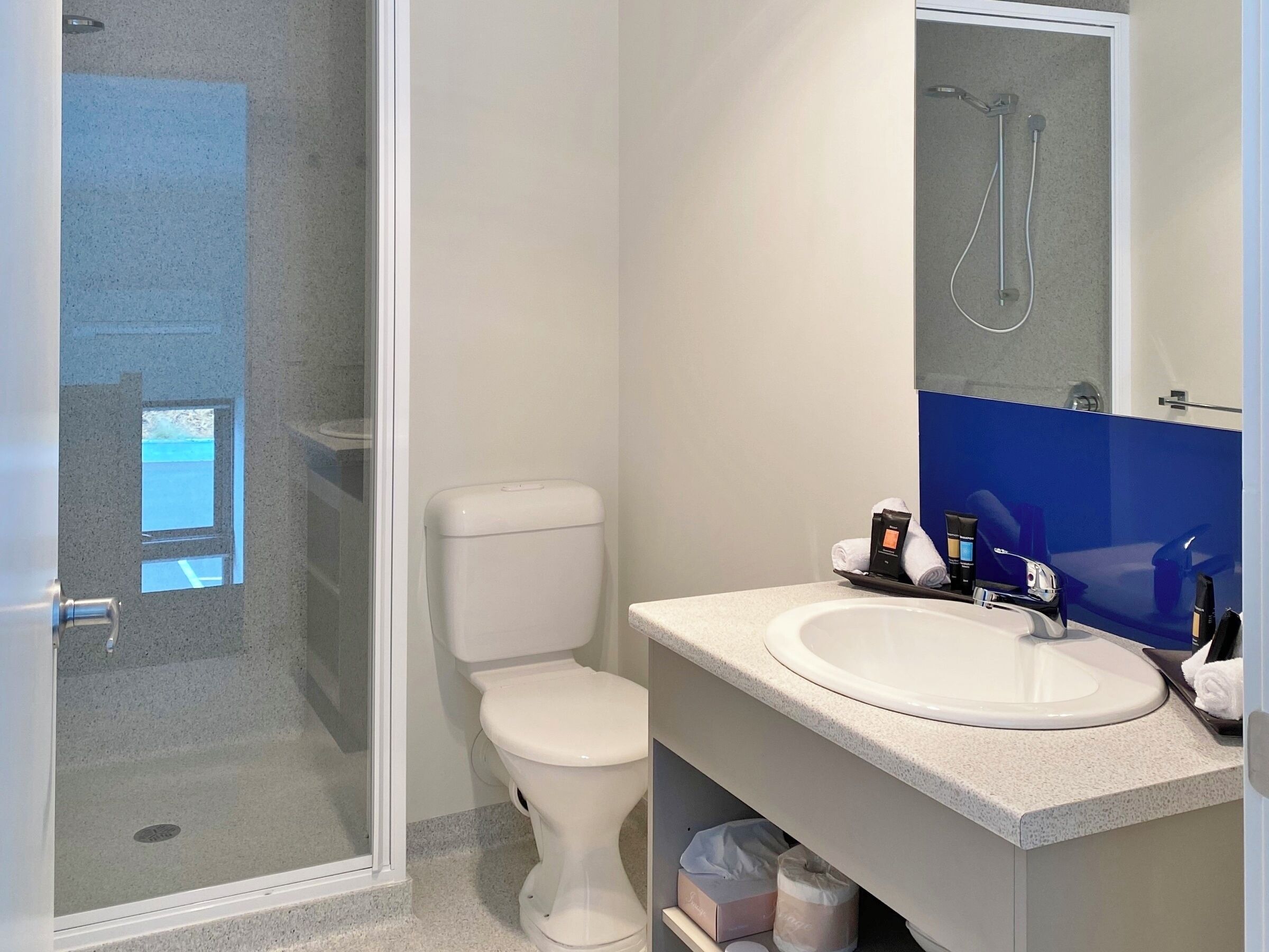 A bathroom with a toilet, sink, and shower.