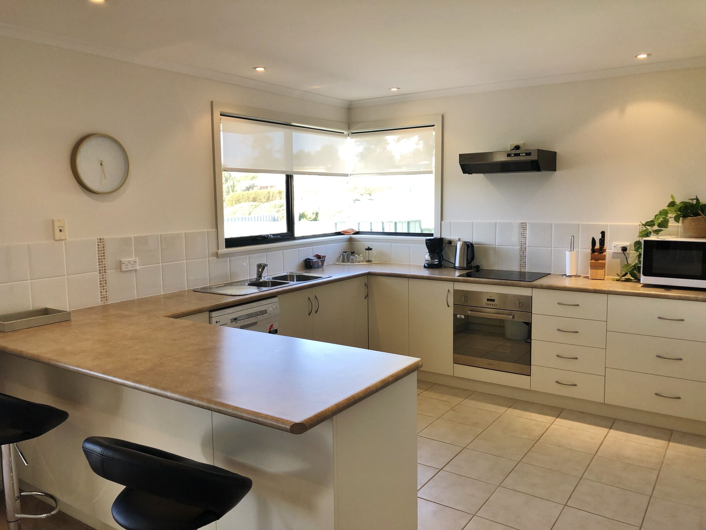 A modern kitchen with a central island, a built-in oven, and a microwave.