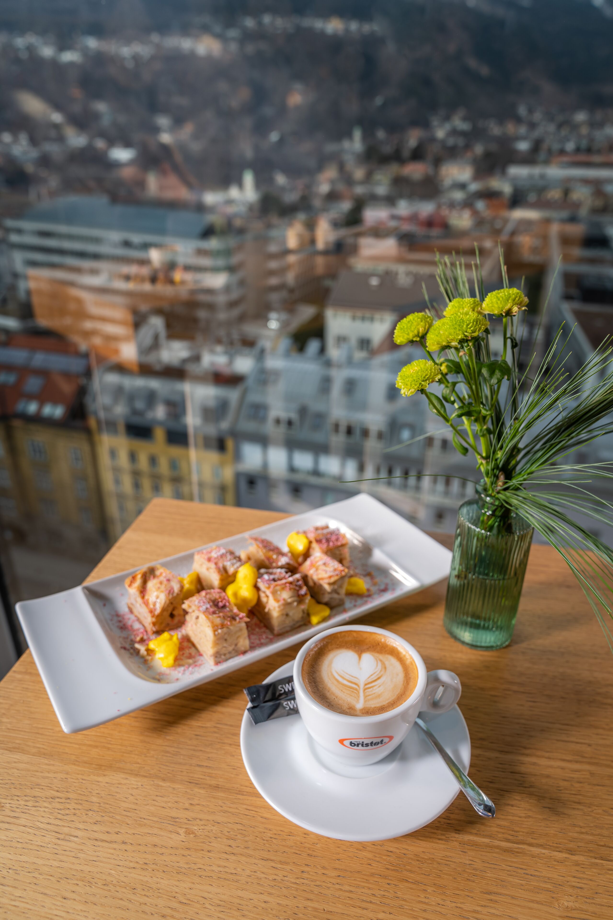 Ein Tisch mit Essen, einer Kaffeetasse und einem Blumenstrauß.
