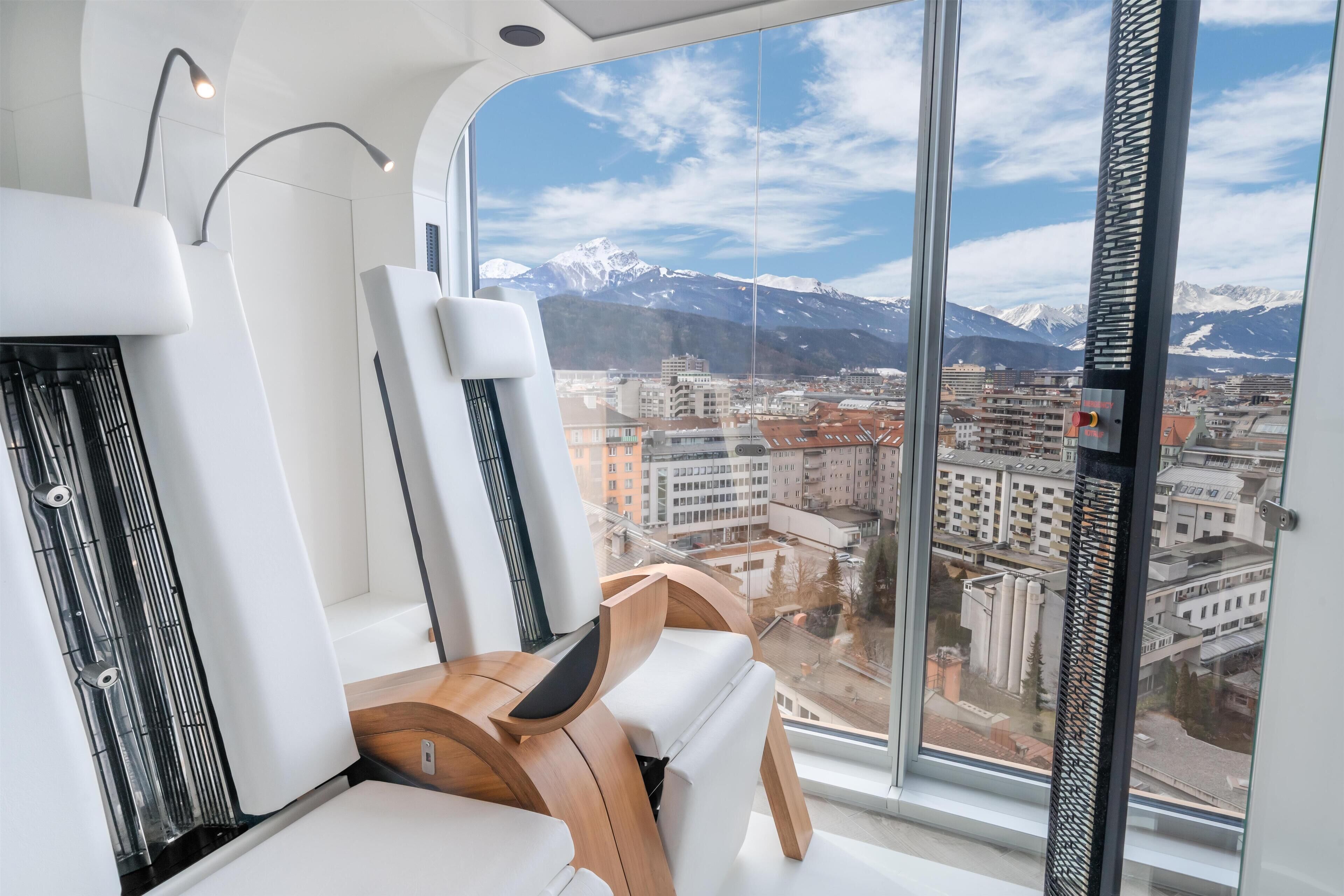 A modern interior with a large window offering a view of a city and mountains.