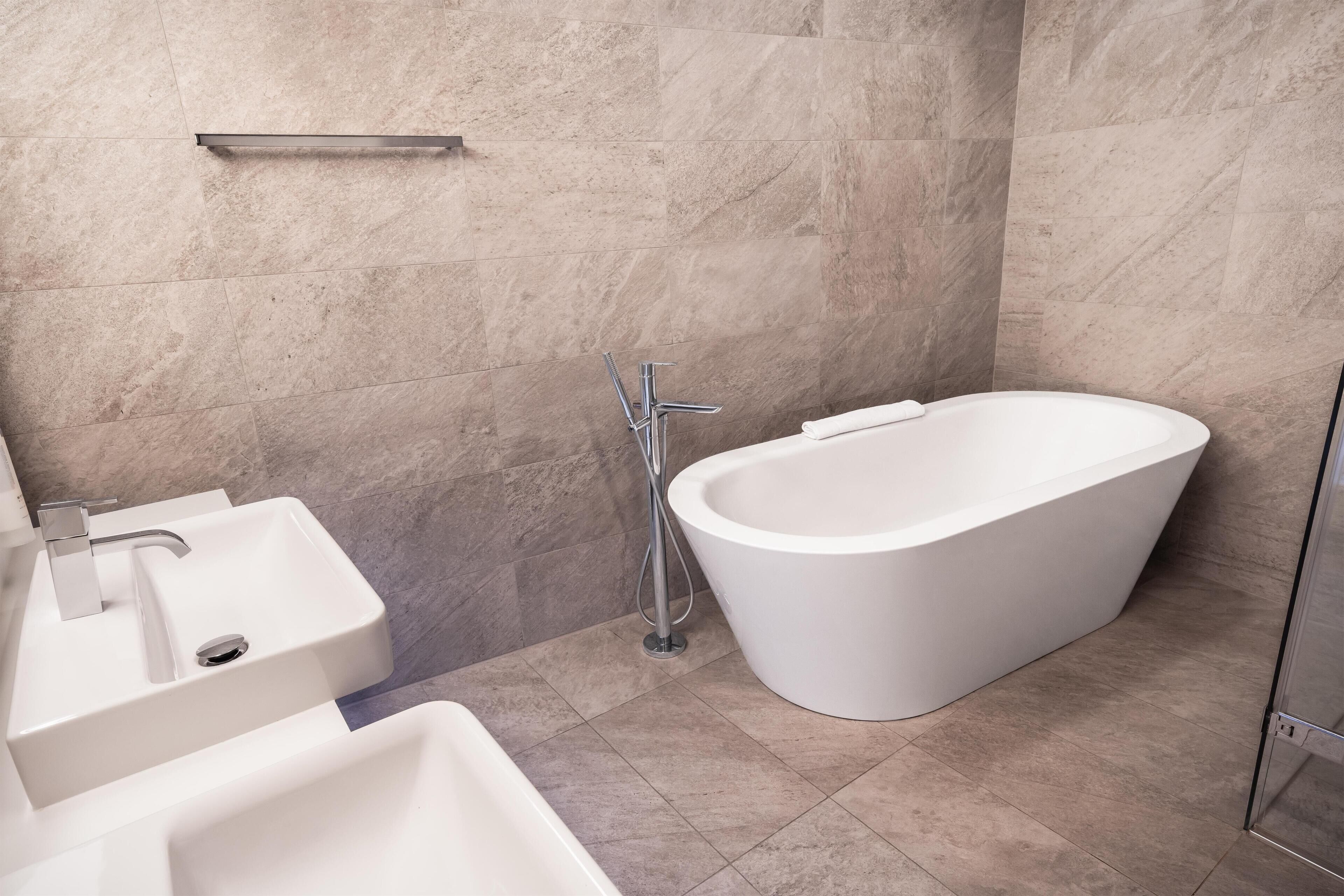 A modern bathroom with a freestanding bathtub, a sink, and a shower.