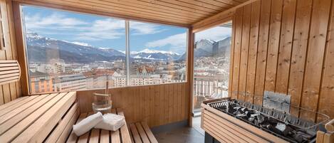 A wooden interior with a large window offering a cityscape and mountains view.
