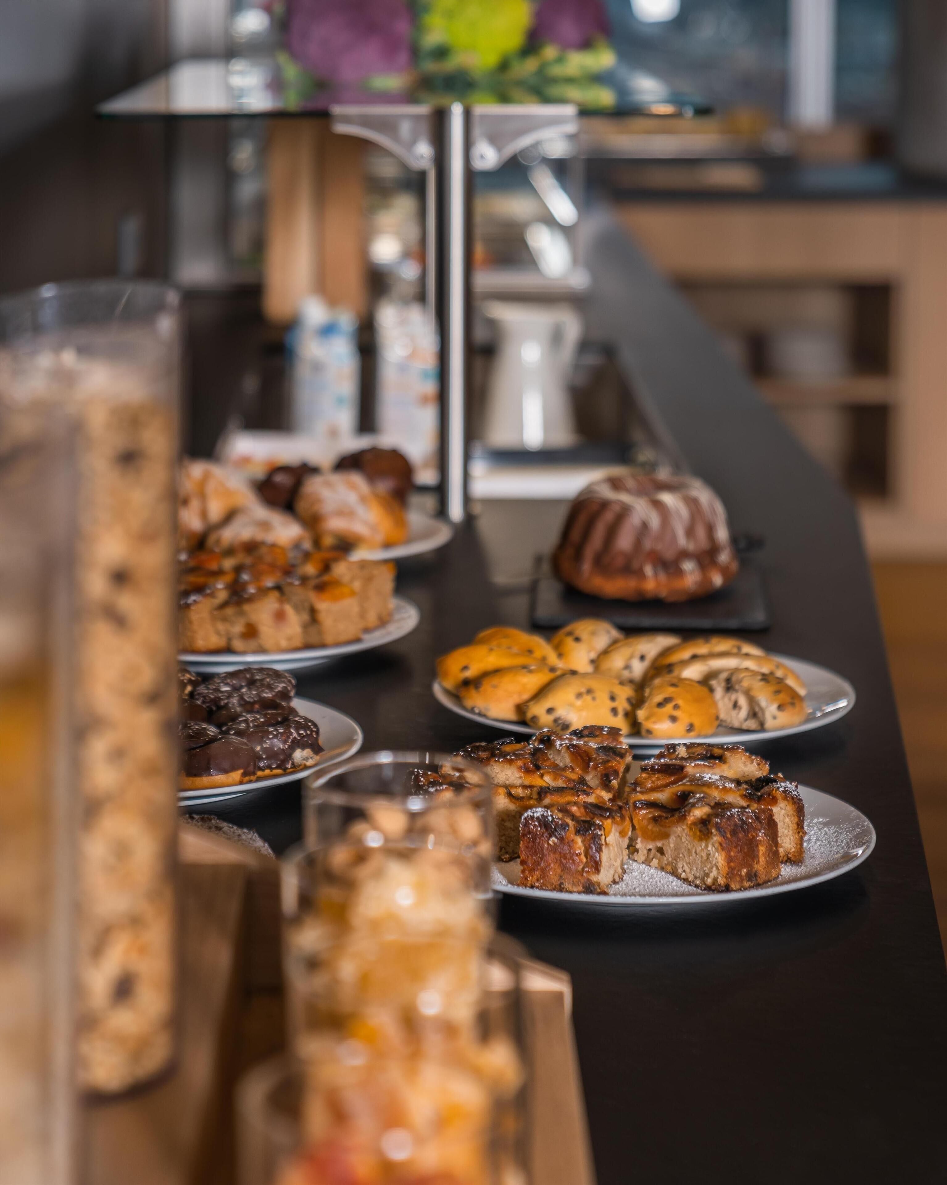 Een buffet met diverse gebakjes en patisserie.