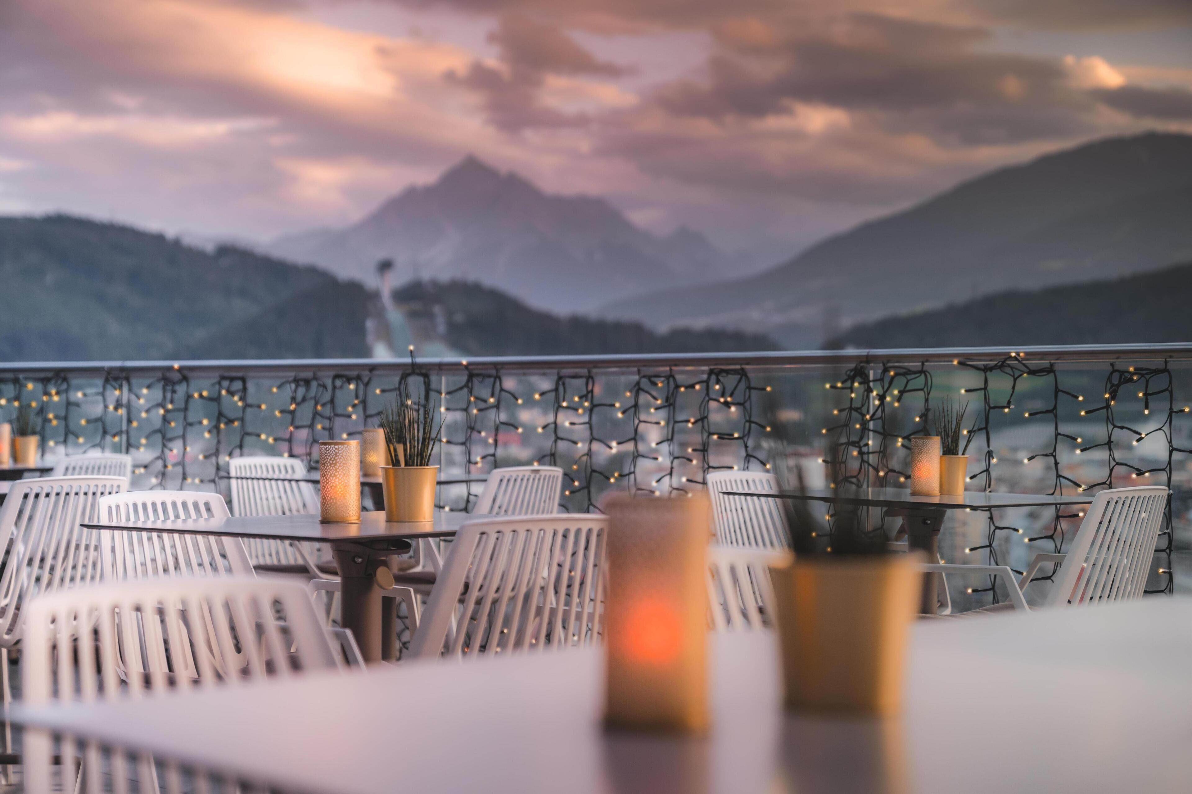 Een restaurant met terras, tafels, stoelen en lichtjes.