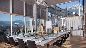 A modern conference room with large windows offering a mountain view, a whiteboard, and a vending machine.