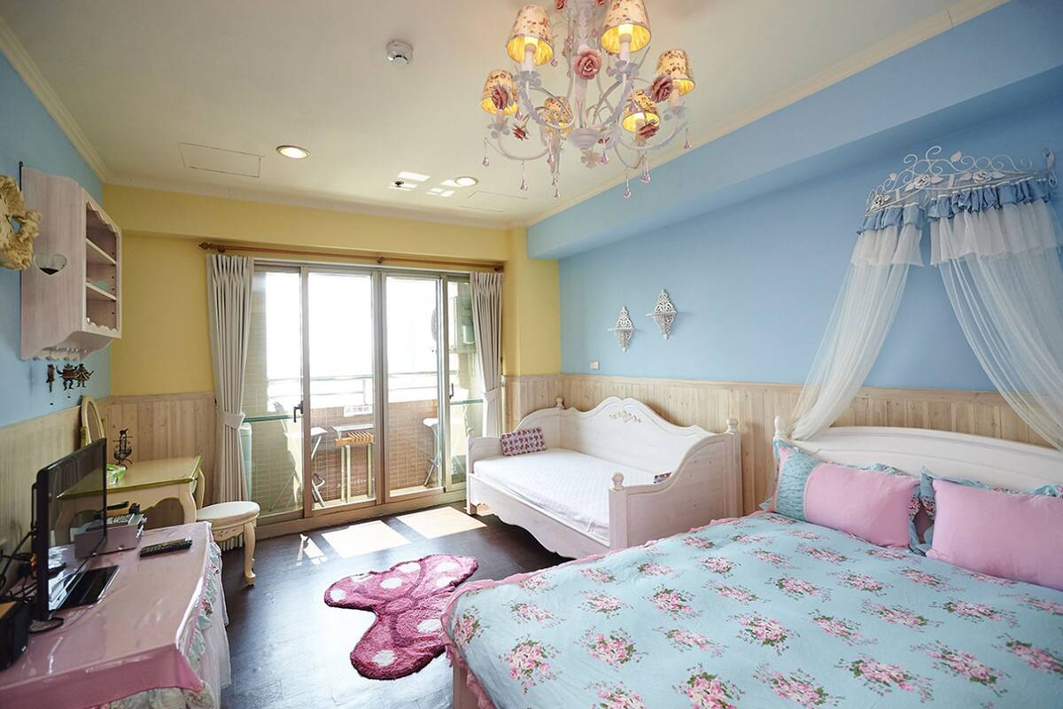 Une chambre à coucher comprenant un lit, un bureau, une chaise, une coiffeuse et un lustre.