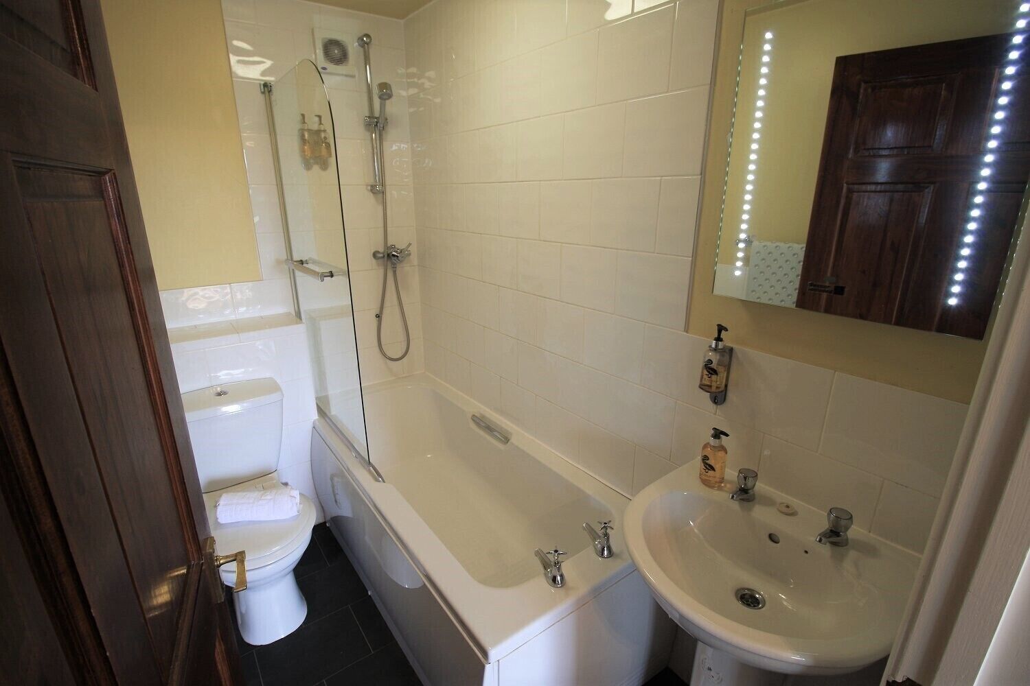Ein Badezimmer mit Toilette, Badewanne, Dusche und Waschbecken.