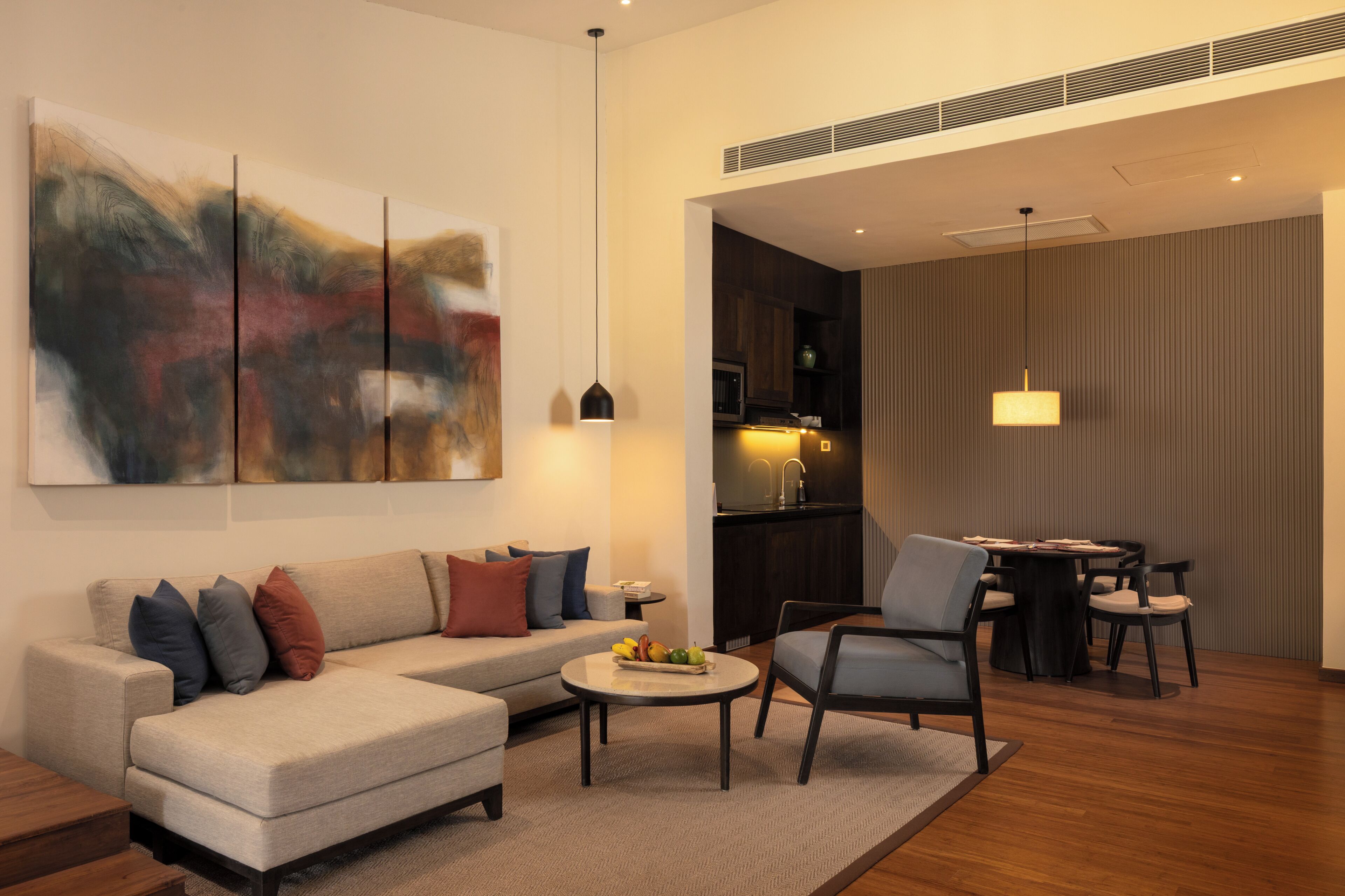 A modern living room with a sofa, coffee table, and dining area.