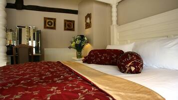 A hotel room with a large bed, a wooden headboard, and a mirror on the wall.