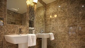 A bathroom with two sinks, a shower, and a large mirror. - The White Hart Hotel (Halstead)