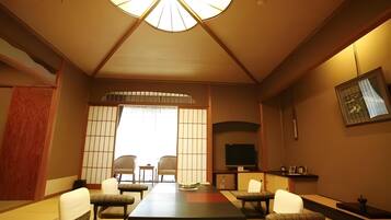 Una habitación tradicional japonesa con suelo de tatami, una mesa baja y puertas correderas.