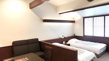 A compact hotel room with a bed, a small desk, and a window.