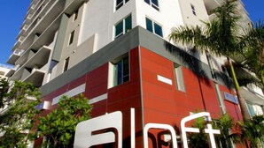 Un edificio de hotel alto con un llamativo letrero de 'W Hotels' en la base.